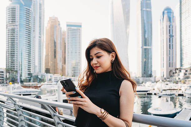 Young woman using smartphone in Dubai Marina