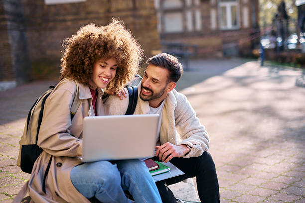 istock University students studying together using laptop outdoors 2209199471