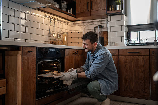 istock Man taking baked food from oven in modern kitchen 2209200326