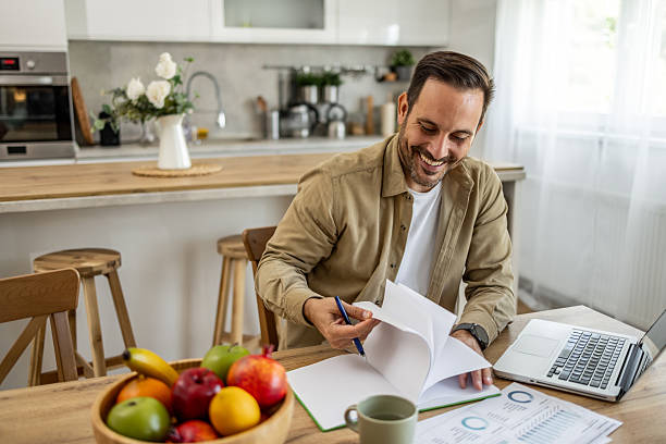 istock Happy businessman working from home reviewing documents and smiling 2209201132