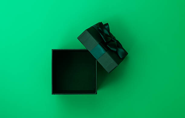 Open gift box with ribbon on green background