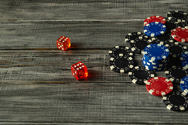 istock A group of poker chips in various colors stacks alongside two red dice on a rustic wooden surface, creating a vibrant and inviting atmosphere for casual tabletop gaming Craps 2209204688