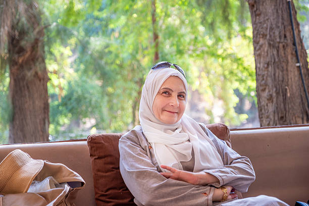 istock Smiling Woman Sitting Outdoors in Casual Outfit with Relaxed Expression 2209211723