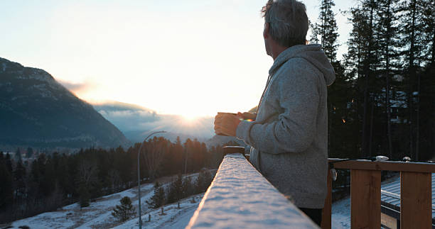 istock Mature man enjoys hot beverage on cabin deck at sunrise 2209213879