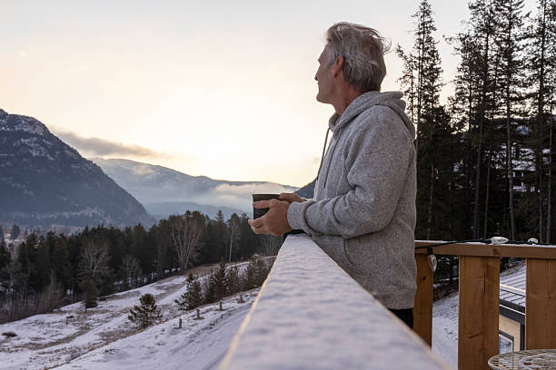 istock Mature man enjoys hot beverage on cabin deck at sunrise 2209213959