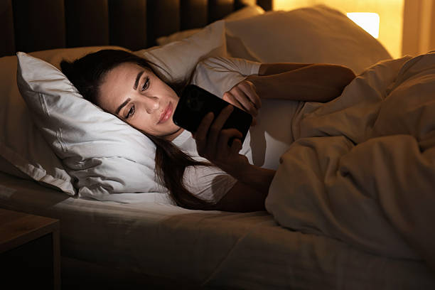 istock Bad habit. Young woman using smartphone in bed at night 2209215816