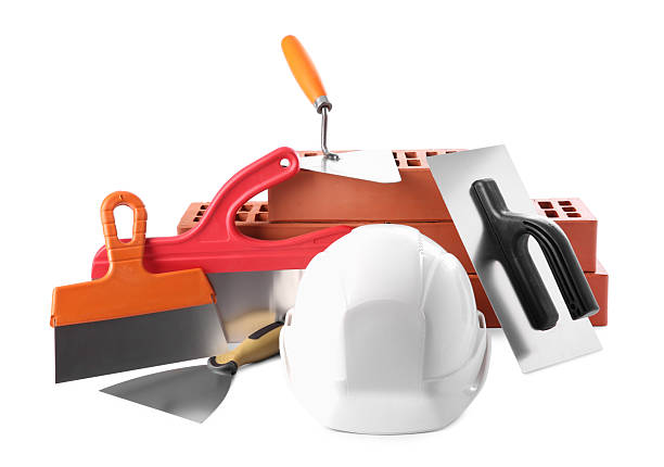 istock Hard hat, red bricks, trowel and putty knives isolated on white. Building material and construction tools 2209220065