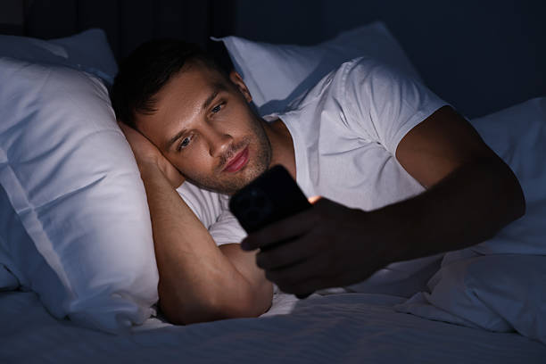 istock Bad habit. Man using smartphone in bed at night 2209220490