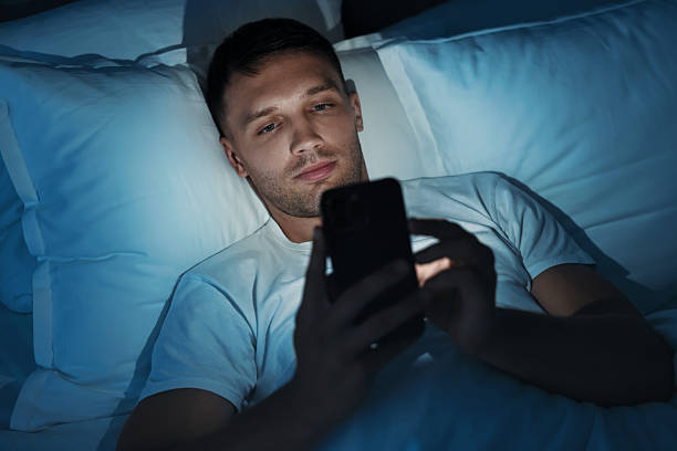 istock Bad habit. Man using smartphone in bed at night 2209220501