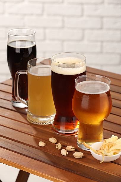 istock Glasses with different types of beer and snacks on wooden table 2209222229