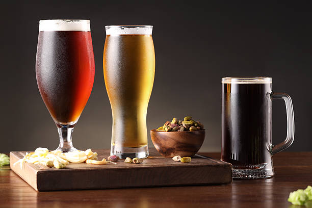 istock Glasses with different types of beer and snacks on wooden table 2209222287