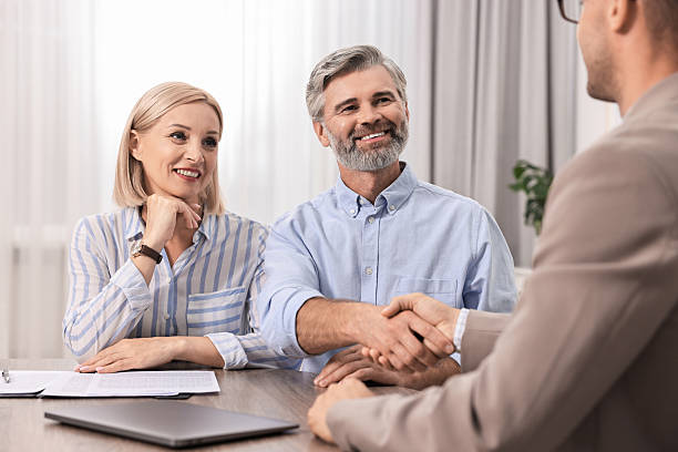 istock Pension plan. Couple consulting with insurance agent at table indoors 2209222665