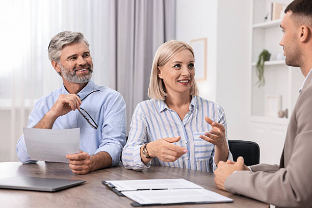 istock Pension plan. Couple consulting with insurance agent at table indoors 2209222756