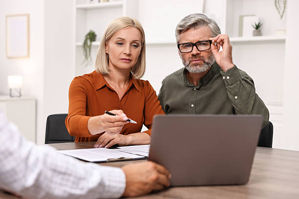 istock Pension plan. Couple consulting with insurance agent at table indoors 2209223006