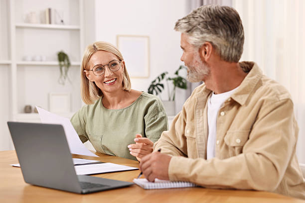 istock Pension savings. Couple planning budget at table indoors 2209223029