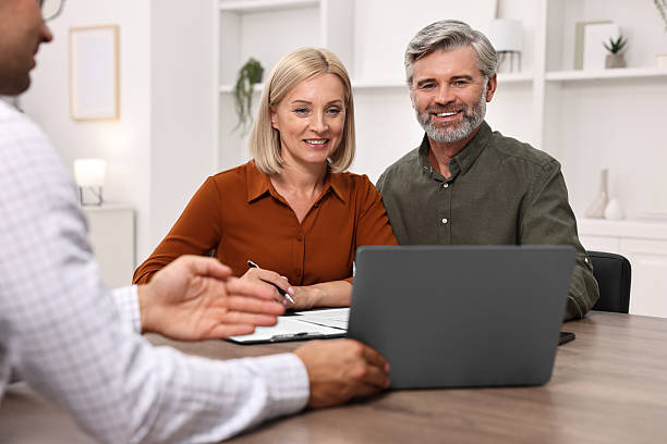 istock Pension plan. Couple consulting with insurance agent at table indoors 2209223107