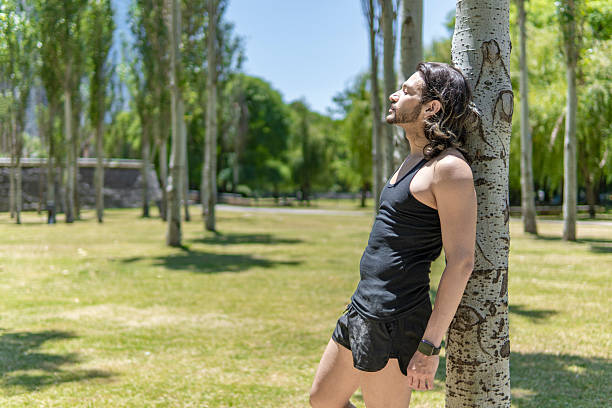 Pensive young latin sportsman resting after working out