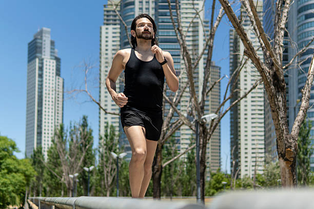 istock Latin man running in modern city with skyscrapers 2209225904