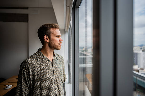 istock Businessman contemplating looking through the window at the office 2209226657