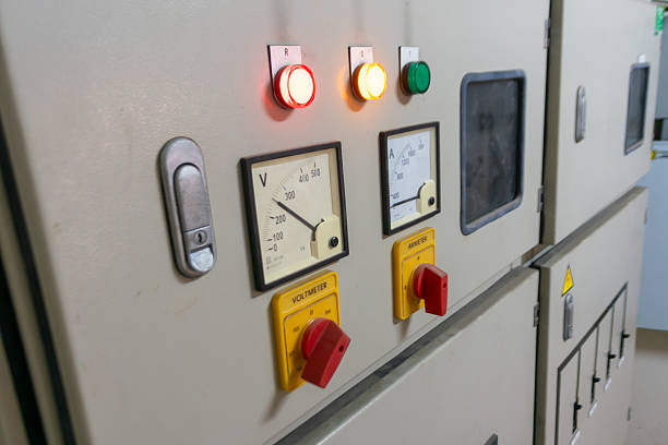 This image shows a control panel in a factory, featuring indicators, meters, and buttons. This equipment is essential for monitoring electrical systems safely and efficiently.
