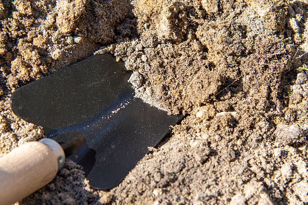 istock garden shovel driven into sandy soil. gardening 2209228834