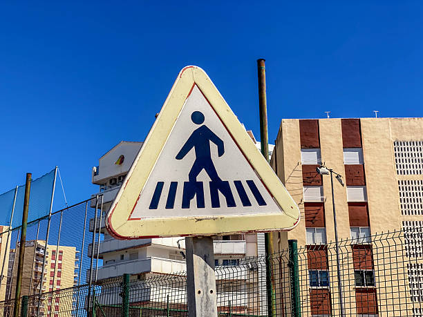 Low angle close-up view of a pedestrian crossing sign in residential district in the town of El Puig de Santa María in the Valencian Community, Spain
