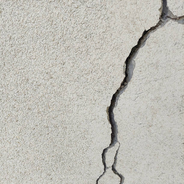 istock Wide vertical winding crack on rough gray cement surface. 2209229630