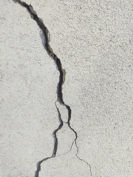 istock Wide winding crack on rough gray cement surface. 2209229634
