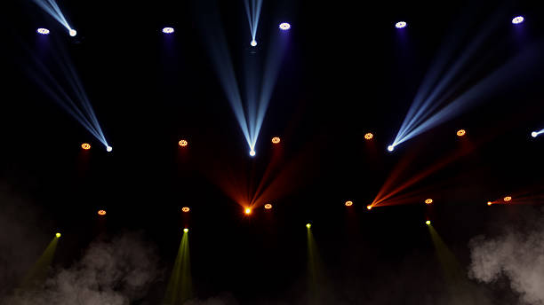 istock Stage lights background. Light beams and smoke from the stage spotlights on the stage at time of show. Laser show isolated on black background. Empty stage with light projector illumination backdrop. 2209232949