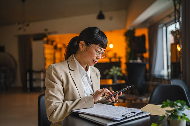 istock Japanese businesswoman use mobile phone and clipboard on work 2209233384