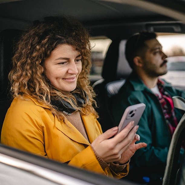 istock Curly hair woman use mobile phone while drive at car with man 2209233776