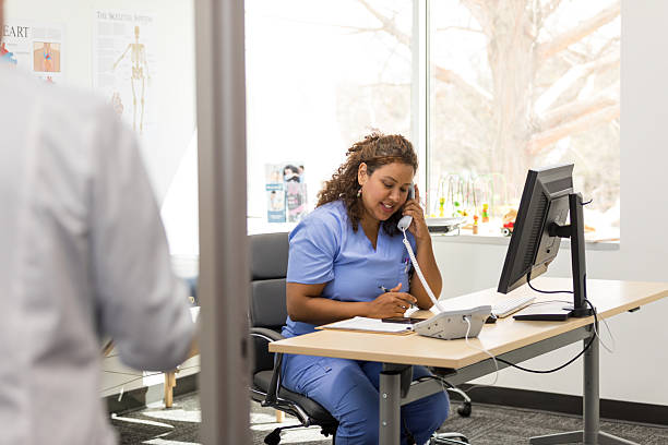 istock Healthcare worker using computer,  making phone calls in office 2209234335
