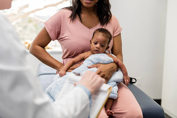 istock Mother holding baby at doctor's office appointment 2209234402
