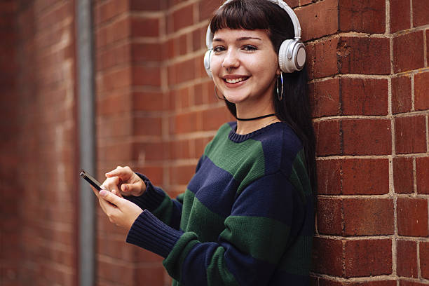 istock Girl with headphones using phone 2209240744