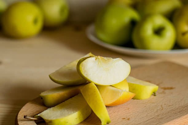 closeup Asian woman slices apples to bake and make dried fruit in her home kitchen - This method helps preserve food reduce waste and extend freshness following a zero waste concept