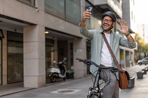 istock Happy businessman video calling while riding a bicycle in the city 2209248607