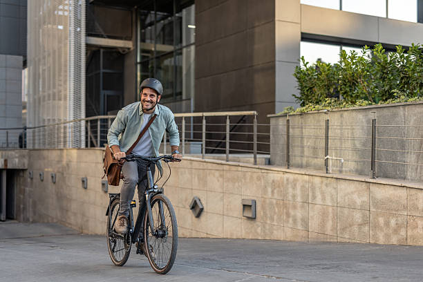 istock Businessman riding electric bicycle in urban setting 2209249234