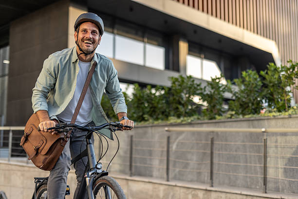 istock Happy businessman riding bicycle to work in urban setting 2209249771