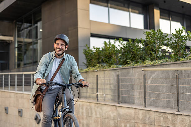 istock Happy businessman riding bicycle to work in urban setting 2209249781