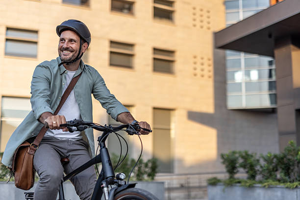 istock Smiling businessman riding electric bicycle in urban setting 2209251672