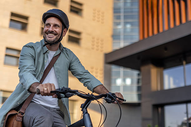istock Smiling businessman riding bicycle in urban setting 2209251703