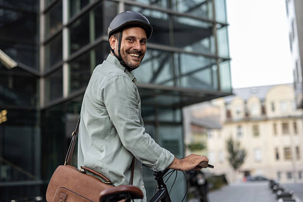 istock Smiling businessman riding bicycle in urban setting 2209251763