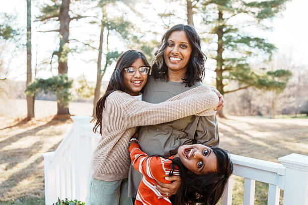 Smiling mom with two playful daughters