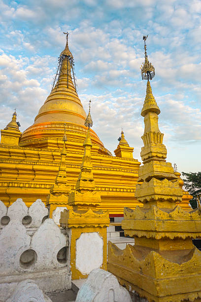 Majestic kuthodaw pagoda, a buddhist stupa, standing tall against a cloudy sky in mandalay, myanmar