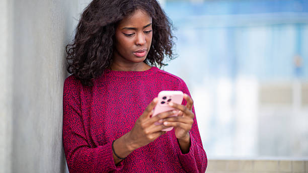istock Young african woman checking messages on phone 2209259629