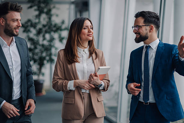istock Businesspeople walking and talking in modern office hallway 2209259910