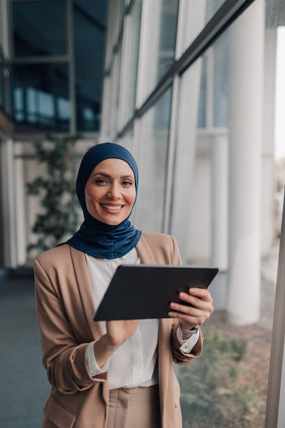 istock Smiling muslim businesswoman using digital tablet in modern office building 2209259977
