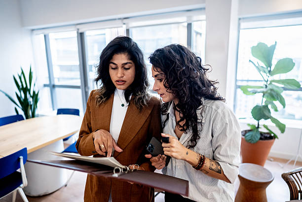 istock Coworkers talking and looking at documents at the office 2209261260