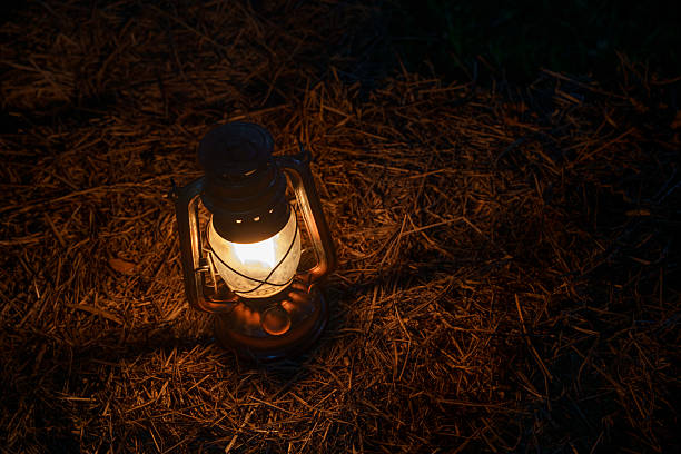 istock antique kerosene lamp with lights on a haystack in a barn at night 2209261552