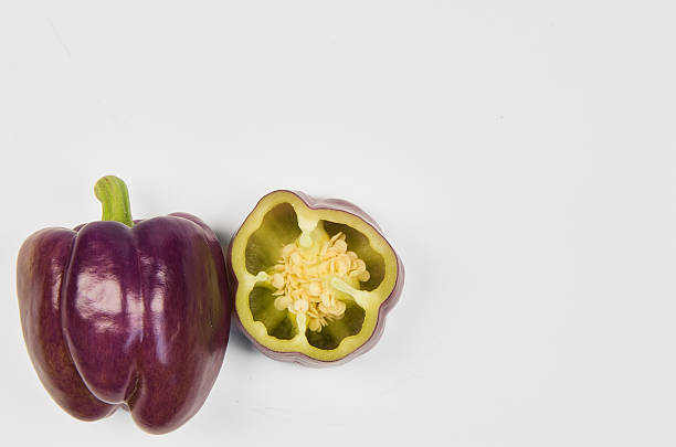 istock Violet Peppers, one of them with a cross section on a white background. 2209261965